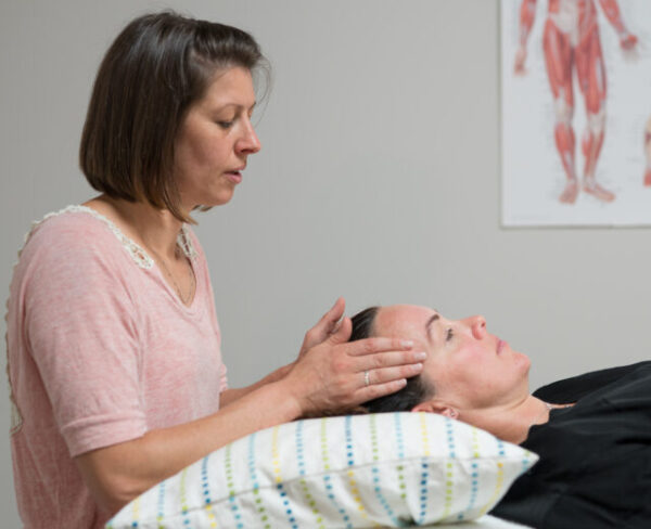 Side view of Amy B giving Reiki with hands on head