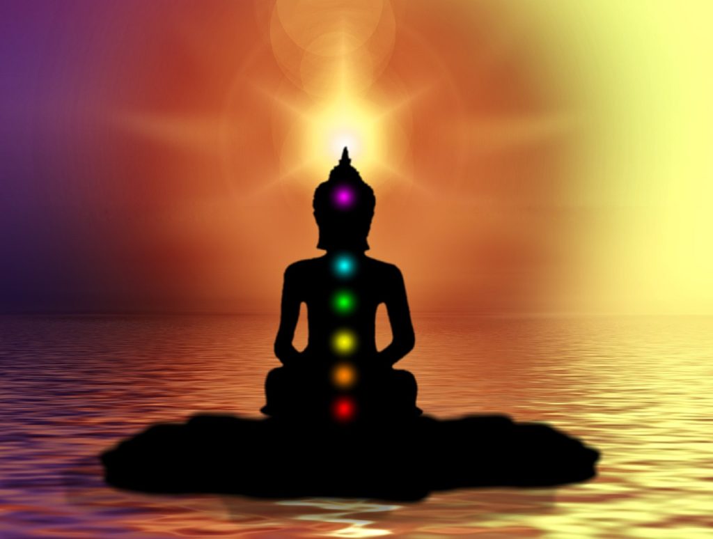 Silhouette of a Buddha with coloured chakras