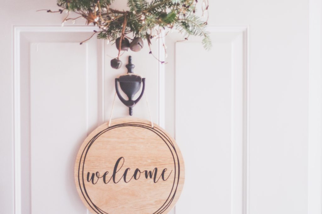 Picture of a welcome sign on a white door