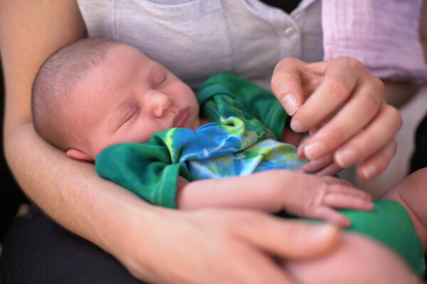 New baby looking very relaxed in mum's arms, Mum giving Reiki to baby