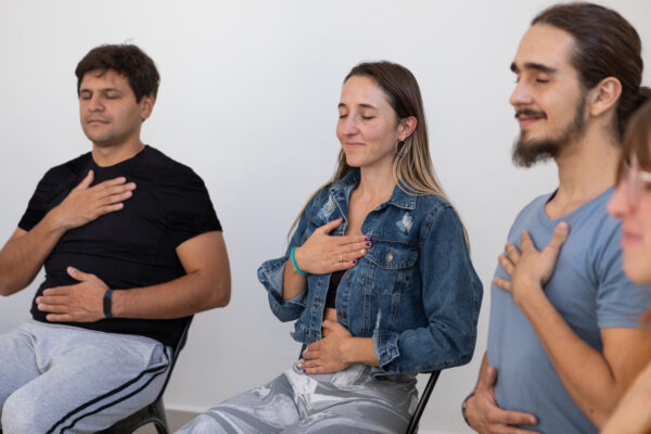 Reiki Students sitting with eyes closed and hands on chest and abdomen