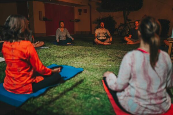 Collective energy amplifies Group of people sitting in a circle meditating, relating to the energy created when people join together