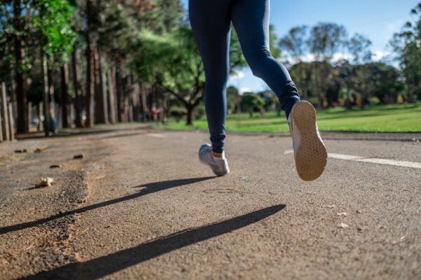 Morning Run — The Inspiration Behind Reiki Mass Close-up of a woman’s feet running along a path near a playing field during sunrise, symbolizing the moment of inspiration that led to the name Reiki Mass.